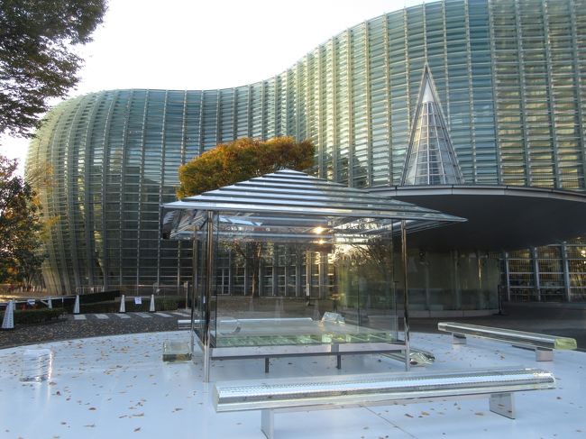 国立新美術館The National Art Center Tokyo 2020.11.18<br /><br />今年は新型コロナウィルスの流行で外出自粛を続けているが、毎年秋の楽しみにしている日展は感染対策に留意して行ってきた。<br /><br />地元の小手指駅から西武池袋線・副都心線直通の快速急行に乗り、明治神宮前で千代田線に乗り換えて美術館直結の乃木坂で降りた。<br /><br />午後4時からのトワイライトチケットでの入館(通常1300円が300円)まで時間があったのでウッドデッキに出てガラス壁の外観を撮ったり、紅茶とマフィンで一休みした。<br />4時からの鑑賞は例年通り1階の日本画を最初に見て、その後2階の洋画の順序とした。最初に写真撮影についての注意書きを読んだ。撮影OKであるが、利用は個人的かつ非営利的な利用目的に限られる。SNSでの利用時はクレジット(作家名・作品タイトル)の表示をすること。<br />この時間帯の入館者は例年通り極めて少なく、三蜜の心配は全くなかった。<br /><br />日本画と洋画の違いは作品を見てもはっきりせず、以前学芸員に尋ねたときの回答も特に決まりがあるわけではないとのことだった。しいて言えば画布・和紙・絹・板などの下地材料と絵具(油性絵具・岩絵具など)で大まかに分類されているようだ。<br /><br />帰りは地下鉄で池袋へ戻り、池袋西武8階ダイニング街のまい泉で好物のとんかつ定食を食べた。テーブルは1卓おきに利用休止の措置がとられていた。<br /><br />撮影 PowerShot SX610HS<br /><br />2013年 <br />小さな旅 霜月の午後の都内めぐり・日展<br />https://4travel.jp/travelogue/10827447<br />2014年 <br />第1回 改組新 日展<br />https://4travel.jp/travelogue/10951544<br /><br />投稿2020.11.20 17:15<br />
