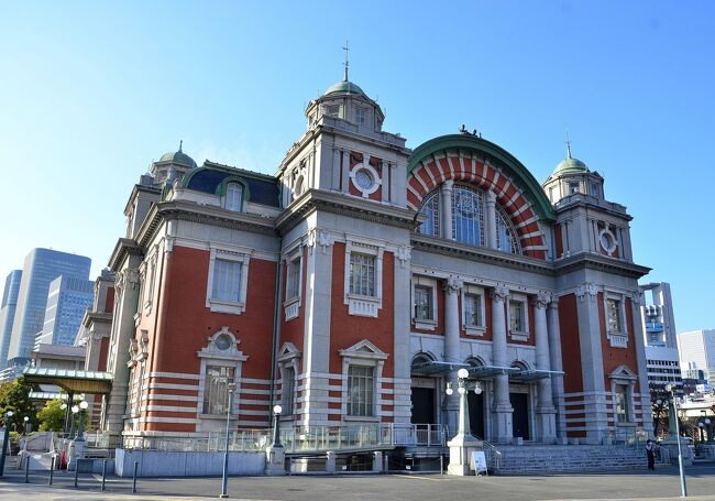 北面に堂島川、南面に土佐堀川が流れる大阪中之島は、パリのシテ島になぞらえて「東洋のシテ島」とも称されています。その東端の中之島公園に面して建つのが鉄骨煉瓦造の大阪市中央公会堂、その西隣に大阪府立中之島図書館が軒を連ね、大阪市庁舎を挟んで御堂筋の向かいには日本銀行大阪支店旧館が並び、この周辺は大正ロマン・ベルトとも呼ばれています。また、国の重要文化財の淀屋橋や大江橋をはじめ、川に架かる橋の数々もそれぞれ個性豊かな意匠で水の都 大阪の美しい景観を演出しています。<br />中でも公会堂は赤煉瓦の壁と青銅葺きドームとのコントラストが美しく、絵になる景観を呈しています。基調となるネオ・ルネッサンス様式にネオ・バロック(フリー・クラシック)様式の要素を加え、細部にはセセッション(ウィーン分離派)様式も取り入れた「様式の大饗宴」といった趣向ながら、威風堂々としており、同時に華やいだ姿でもあります。水の蒼と木々の緑に映える外観も美しく、中之島のシンボルに相応しい風合いです。