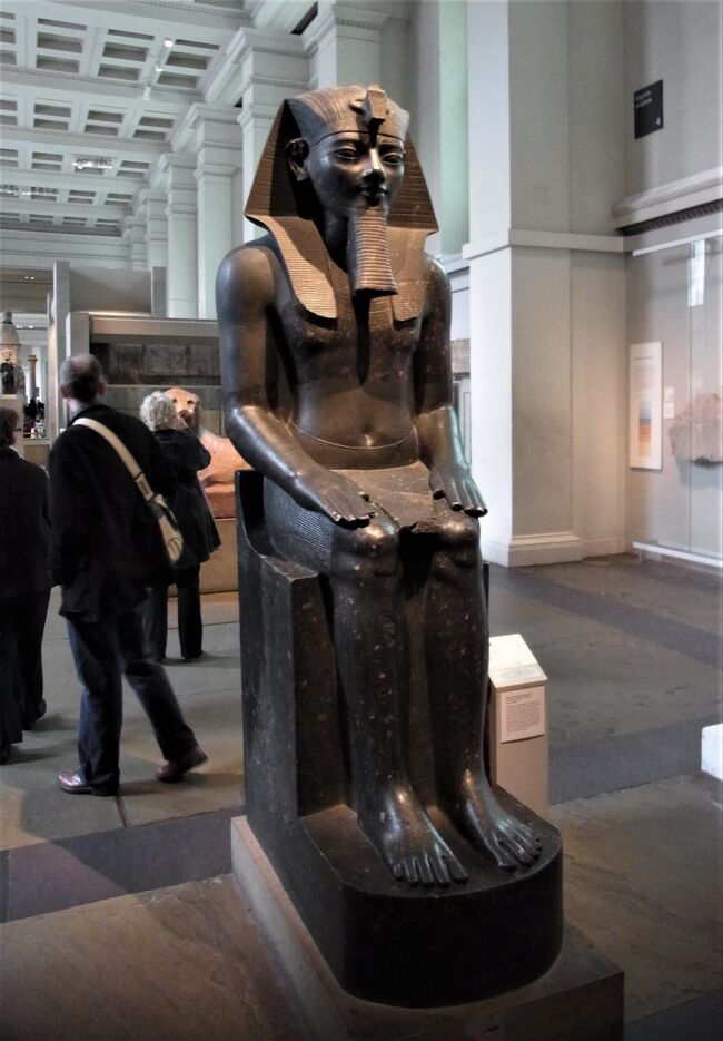 古い写真を見直すシリーズ。<br /><br />引き続き、大英博物館で、２０１３年３月に４日間に渡って撮影した２２００枚の写真から、テーマ別に取り上げている。<br />今回は人気のエジプト文明関係の部屋にある目立つ展示の説明版と展示品の写真を中心に出したい。<br /><br />大英帝国の繁栄時期には、帝国内に日が沈まないほどの威勢を誇ったが、それら旧植民地との外交関係は総じて未だに良好だ。英語も押し付けたことはないのに、自然に受け入れられていることが多い。それに旧植民地から英国の大学に行って学ぶことに抵抗が低かったようだ。旧植民地のコインや切手に英国女王の顔が出るという習慣や、大英連邦の交流も、いまだに続いているのも驚きだ。<br /><br />そういった強力な大英帝国や連合王国との付き合いをうまくやった明治時代の日本外交は今思い返してもすばらしい。日英同盟を結べたことも当時としてはすばらしい外交の成果だったと思う。まがりなりに、日清戦争、日露戦争が勝利できた理由だ。もっとも、日本外交はその後、軍人タイプの無教養な連中に握られ、最悪の三国同盟を結びながら坂道を転げ落ちていった。<br /><br />大英博物館のエジプト展示品関係は、主要なものはナポレオン軍を破った大英帝国にフランスから戦利品として移譲されたもので、ロゼッタ・ストーンも、英国に移った後で、フランス人が解読した。アテネの神殿の彫刻品などは、当時トルコ領だったアテネにあったものを、ちゃんと英国側が交渉して入手したものだ。時々、大英帝国が分捕ったなどという話が出回ったりするが、そんなに簡単に強奪できるわけではない。（どこかの国みたいに、仏像を盗んで持ち帰っても、歓迎されるなんてのは普通ではない。）ただし安く買いたたく術は凄いのだが。。。日本の浮世絵なども、恐らく二束三文に売り渡してしまった。安く売る方が悪い。今、買い戻すと、北斎なども何千倍も払わないといけないのだ。英国人のコレクションは個人レベルのものも凄まじい。税金対策で、受け継ぐのが大変になり、しばしば国立博物館などに寄贈されていき、今のような巨大なコレクションが揃ってきたという側面もある。<br /><br />一枚目は、エジプト、第１８王朝のアメンホテップ３世王の像（BC１３５０年頃）<br />（２０２０年１２月６日記す。）  <br /><br /><br /><br /><br /><br />