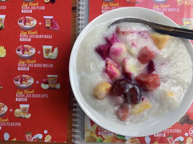 家の近くに出来た、新しいお店『KING Juice』<br />美味しそうなフレッシュ&ヘルシーフルーツがいっぱい!<br />フルーツジュースやフルーツサラダ、エスチャンプル(フルーツかき氷)などが食べられます。<br />メニューもいっぱいあって迷います😆<br />この日は「es buah kuah sirsak」を食べました。シルサックと言う、甘くて、ヨーグルトっとぽい味の果物のかき氷です。<br />シルサックは英語でサワーソップと言うみたいです。<br />ギャニャール夜市の近くに出来ました。<br />美味しかったので、また行きたいです❗️
