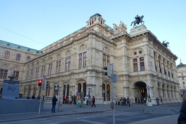 皇帝フランツ・ヨーゼフ1世の命によりウィーン都市改造が行われ、城壁を撤去して環状道路が建設されました。それがリンク大通り。<br />そしてリンクの両脇には様々な様式の建物が造られました。<br />例えば、国会議事堂は古代ギリシャ様式、市庁舎は中世ゴシック様式、郵便貯金局はユーゲントシュティール様式、ウィーン大学はルネッサンス様式、ブルク劇場はバロック様式などなど。<br /><br />ウィーン国立歌劇場（当時はウィーン王立宮廷歌劇場）はネオルネッサンス様式で建てられました。しかし皇帝フランツ・ヨーゼフ1世はこの建物を見て、「沈んだ箱」と酷評したそうです。その評価を気に病んだ設計者は自殺しました。<br />確かに2階部分より1階部分の方が低く、道路に沈んでいるように見えないこともありませんね。<br /><br />そして1945年3月、ウィーン旧市街はアメリカ軍の空爆により壊滅的な大被害を蒙りました。ウィーン国立歌劇場もその例にもれませんでした。<br /><br />今回はウィーン国立歌劇場見学ツアーで見た豪華な劇場内部と、ドイツ併合時代のナチスとウィーン音楽界とのかかわりもお伝えできればと思います。<br /><br />