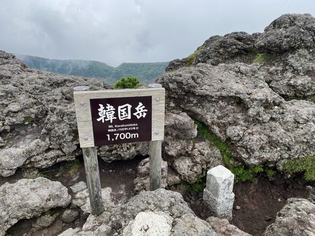 星野リゾート界 霧島に一泊し(こちらの滞在記は下記)、<br />https://4travel.jp/travelogue/11696206<br /><br />翌朝は「えびのエコミュージアムセンター」前の駐車場に車を止めて韓国岳に登って見ました。<br /><br />昨年秋に挑戦しようとしましたが、台風並みの強風で断念したのでリベンジです。<br /><br />時期的にはミヤマキリシマが見頃を迎えていましたが、今年は天候不順で生育不良らしく、咲き誇るという感じではなかったですが、一部では綺麗な姿を見せてくれました。<br /><br />往路は駐車場脇の登山口から、硫黄山火口展望所を経由して、頂上に到着するまで休憩を入れて1時間45分(標準所要時間と同じでした)。鹿児島の山は溶岩がゴロゴロしている箇所が多く歩きにくいので、62歳、63歳の夫婦としてはまずまずの時間でしょう。<br /><br />頂上からは高千穂峰など眺めてみたかったのですが、好天の予報だったのにガスが急激に広がり、全く見えず(またまた宿題が残った感じ)。大浪池方向は一時だけガスが切れて見えました。やはり山の天気は変わりやすいので注意が必要です。<br /><br />ホテル夕食の残りご飯で作ってきたおにぎりなどで、頂上付近でランチタイムにして30分ほど休憩しました。<br /><br />復路は頂上近くの分岐点から大浪池方向にくだり、避難小屋の横から林の中を抜けて、つつじケ丘登山口から道路に出て駐車場に戻りました。約2時間20分かかりました(標準所要時間1時間45分)。<br /><br />このルートは木製階段の急坂が多く、崩壊している場所もあって段差があるので、ポールを使用しても足に負担がかかり、くだり切る頃には膝裏靭帯が痛くなりました。ふくらはぎの筋肉痛は登山後数日は激しかったです。<br /><br />服装は、上は半袖速乾Tシャツに長袖速乾ジッパーシャツ、下はモンベルのトレッキングタイツに薄手のトレッキングパンツという重ね着。ガスで日差しが弱かったのでそれほど暑くはなかったです。<br /><br />靴はくるぶしまでカバーするトレッキングシューズと分厚めのトレッキングソックス。<br /><br />他に帽子、薄手の手袋、冷感タオル、サングラス、伸縮性ポール1本(2本にすれば良かった)、念の為フリースの薄手、ゴアテックス雨具上下、シューズカバー(ゲイター)、救急袋、テッシュ、除菌ウエット、携帯電話用バッテリー、非常食、水1.5Lなどをデイパックで背負って行きました。<br /><br />途中にトイレはありませんので、念のため携帯トイレも持って行きました。