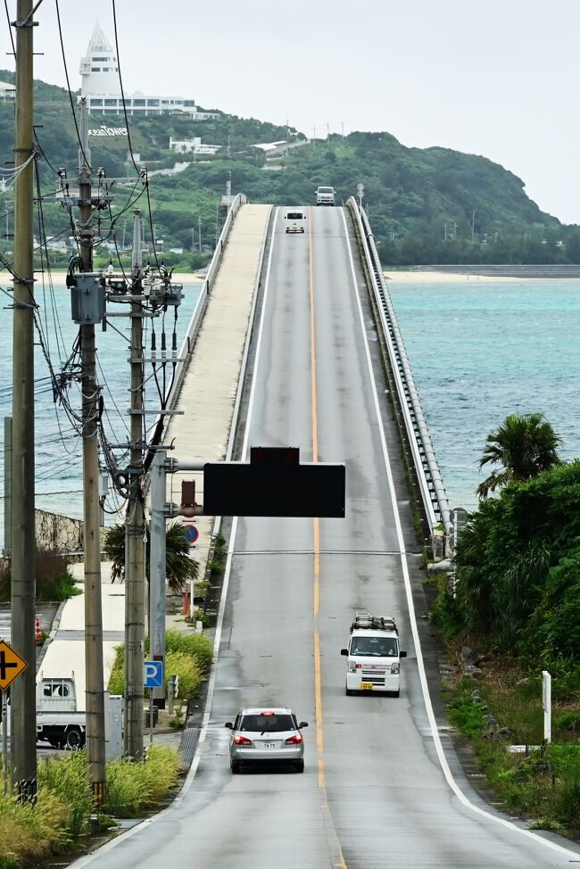 スッキリした青空になってくれません、それどころか雨が降ったり止んだり。<br />そんな中、以前から行ってみたかった古宇利島に行きます。ホテル出発時にはとんでもなく激しい雨になりました。ホテルのコンシェルも心配そうな顔で傘を出してくれました。しかし向かう北方向は明るいので何とかなると楽観しています、それでも一応昨日雨乞嶽で授かったパワーを用いて「雨よ降るなー」と念を送ります。いや、まてよあれは雨よ降って下さいパワーだったか?