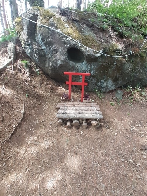 五重塔の少し上に展望休憩所がある。外人観光客は五重塔と富士山のペアリングの写真が撮れれば、それで十分満足するので、この上の展望台まではやってこない。五重塔の写真を撮ったらそれで目的達成だからＵターンして下山する。この展望台までやってくるのは地元の人位だ。自分達は時間があるので、そこまで登る。中学生位の少女が２‐３人、そこで休んでいた。街中の不健全な場所で遊ぶよりは、余程か健全だ。真正面に富士山が見え、下の五重塔の場所よりも、より雄大に見える。正に富士山と対座する。<br /><br />「笠雲の棚引く富士に対座せり」<br /><br />休憩所で一休みし、ここまで登ってきて更に欲が出てきた。この新倉山の高さはどの程度か分からないが、稜線を見たところ７－８００ｍ程度だろう。遊歩道のように整備された登山道も出来ている。どこまで登れるか分からないが、行ける所まで行ってみよう。Ｉｎａさんと相談し、登れる所まで登ってみよう、と登山を開始した。殆ど無人のように思えた山道だったが、矢張り、数少ないながら地元の登山者もいる。今日は土曜の休みで天気も良く、地元の人にとっては手頃なハイキングコースになっているようだ。<br /><br />登り始めて１０数分、矢張り脚力は随分と落ちていて、近くに見えた稜線に行くのも中々大変だ。途中の山道標識にゴロン石という案内があり、どうも山頂の中腹にあるようで、取り敢えずはそこまで登ることにする。今日の処は山頂までの往復は諦めよう。丁度登って来た元気そうなスポーツマンタイプの男性に場所を確認すると、ゴロン石はもう直ぐそこ、５－６分で行けるとのことで、頑張ってそこまで登ることにした。<br /><br />富士山の過去の噴火で吹き飛ばされた岩石なのか、登山道の周りに大きな岩のような岩石がゴロゴロしている場所に来て、その奥に一際大きな巨岩があって、何か小さな鳥居もあって、この磐が霊廟のようになっている。地元の一部の人にとっては神聖な場所なのだ。霊岩にお参りし、そこの前で一休みし、今回は新倉山の山頂は諦め、下山することにした。