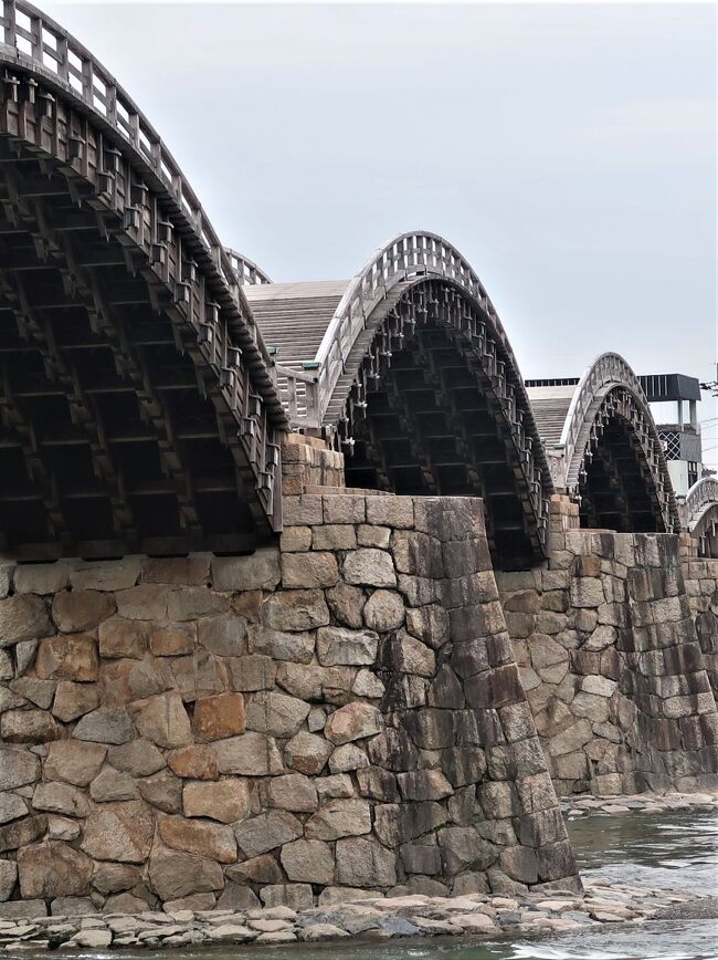 錦帯橋（きんたいきょう）は、山口県岩国市の錦川に架橋された、5連の木造アーチ橋である。<br />日本三名橋や日本三大奇橋に数えられており、名勝に指定されている。「錦帯橋」という美名は、完成後に定着した説が有力とされている。<br />5連のアーチからなるこの橋は、全長193.3メートル、幅員5.0メートルで、主要構造部は継手や仕口といった組木の技術によって、釘は1本も使わずに造られている。 石積の橋脚に5連の太鼓橋がアーチ状に組まれた構造で、世界的に見ても珍しい木造アーチ橋として知られる。 また美しいアーチ形状は、木だけでなく、鉄（鋼）の有効活用がなされて初めて実現したものである。杭州の西湖にある堤に架かる連なった橋からヒントを得て、1673年に創建された。西湖の錦帯橋とは2004年に姉妹橋となっている。現在、そのほとりには、錦帯橋友好の石碑が建立されている。桜の名所として、吉香公園と共に日本さくら名所100選に選定されている。<br /><br />錦帯橋は1673年（延宝元年）に、岩国藩主吉川広嘉によって建造されたものである。初代岩国領主の吉川広家が岩国城を築城して以来、岩国城と錦川を挟んだ対岸にある城下町をつなぐ橋は数回架けられているが、錦川の洪水により流失していた。<br />3代領主の広嘉は、洪水に耐えられる橋を造ることに着手する。広嘉がある日、かき餅を焼いていたところ、弓なりに反ったかき餅を見て橋の形のヒントを得たという。また、明の帰化僧である独立性易から、杭州の西湖には島づたいに架けられた6連のアーチ橋があることを知り、これをもとに、連続したアーチ橋という基本構想に至ったともいわれている。アーチ間の橋台を石垣で強固にすることで、洪水に耐えられるというのである。<br />延宝元年（1673年）6月8日に基礎の鍬入れが始められ、児玉九郎右衛門の設計により、石で積み上げられた橋脚を川の堤防に2個、中間に4個の計6個築き、その上から片持ちの梁をせり出した木造の5連橋を架けた。広嘉は近くに住居を構えて自ら架橋工事の監督を行い、扇子を開いてアーチ橋の湾曲の形を決定したという。同年10月、錦帯橋は完成し、地元で家内睦まじいことで評判の農家清兵衛の一家12人による渡り初めが行われた。しかし、翌年の延宝2年（1674年）、洪水によって石の橋脚が壊れ、木橋も落ちてしまったので、同年、家来に石垣の研究をさせて橋台の敷石を強化し再建した]。この改良が功を奏し、その後は昭和期まで250年以上流失することなく定期的に架け替え工事が行われ、その姿を保った。<br />なお、橋は藩が管理し、藩内では掛け替え・補修の費用のために武士・農民など身分階級を問わず「橋出米」という税が徴収されていた。ただし当時、橋を渡れるのは武士や一部の商人だけで、一般の人が渡れるようになるのは明治に入ってからであった。<br />明治時代になり橋を管理していた岩国藩が消滅すると、1895年に地元有志による「錦帯橋保存会」が設立され、掛け替え資金の募集を行うようになる。<br />1922年3月、史蹟名勝天然紀念物保存法により名勝の指定を受ける。<br />1950年（昭和25年）9月14日、折からのキジア台風により第四橋の橋脚から崩壊し、錦帯橋はほぼ完全に流失してしまう。276年間流されなかった錦帯橋が流失した原因としては、橋の補修が疎かになっていたことや、上流域の森林伐採が進み保水力が落ちていたこと、大量のバラス（砂利）を採取したことで河床の落差が急に大きくなっていたことなどの要因が指摘されてもいる。翌1951年から復旧工事が始まり、1953年（昭和28年）に再建が完了。コンクリート製での再建案もあったが、市民の求めで木製で再建された。<br />2001年（平成13年）より2004年（平成16年）に26億円をかけて、約50年ぶりに橋体部分の架け替え工事が行われた。工事は各年の晩秋から早春の、錦川の水量が減る時期に施工された。<br />2005年（平成17年）9月6日から翌7日にかけて九州北部・山陰沖を通過した台風14号により、第一橋の橋脚2基が流失した。後に約4000万円かけて復旧工事が行われ今に至る。<br /><br />川幅約200メートルの河川内に4つの橋脚を持つ5連の木造橋で、中央3連がアーチ橋、両端が桁橋構造を持つ反橋となっている。長さはアーチ橋が35.1メートル]、桁橋は34.8メートル。<br />アーチ橋の構造は、左右の橋脚を起点に橋桁の1番桁から11番桁まで順次勾配を緩めながら先に突き出るように重ねていき、9番桁鼻間に大棟木（おおむなぎ）、10番桁鼻間に小棟木を入れる。<br />こうした構造形式は世界的にも珍しく、ユネスコの世界遺産に登録されている橋梁の中にも、類似の構造をもった木造橋は見られない。<br /><br />現在の橋体に使われている木材はアカマツ、ヒノキ、ケヤキ、クリ、カシ、ヒバで、木材の特性により使い分けられている。平成の架け替えの際は全国から約7年かけて木材が集められ、100％国産材で造られた。なお、桁橋の橋杭には本来のマツに代え、腐りにくい青森県産のヒバが初めて使われた。<br />一方、橋脚の石垣や河床の石畳は創建後に造り替えられた記録はなく、昭和の再建の際も崩壊した石材を集めて造り直された。このため、錦帯橋で唯一、創建時の部材が残っている箇所と言われている。ただし石垣の内部には、昭和の再建の際にコンクリートが打ち込まれている。<br /><br />錦帯橋は、創建時から現代までの修復記録が藩政の史料などでほぼ完全に残り、歴代の大工棟梁の人物名も全て分かっている。<br />記録によると、江戸期にはアーチ橋（第二、第三、第四橋）は約20年ごと、桁橋（第一、第五橋）は約40年ごとに架け替えられ、橋板や高欄は約15年ごとに取り替えられてきた。現代までに行われた架け替え工事の回数は、第一橋10回、第二橋14回、第三橋14回、第四橋16回、第五橋9回である。橋自体は50年以上持つにもかかわらずこうした手法が採られたのは、大工技術の継承の意味合いが大きかったと推測されている。<br />現存する絵図面は、2回目の架け替えとなる1699年（元禄12年）のものが最古。そのほかにも12枚が残る。これらの架け替え記録から、架け替えのたびに改良が加えられ、1796年（寛政8年）の改良で現在の形状が定まったことがわかっている。以後210年間、形状や意匠の変更はされていない。<br />平成の架け替えの際は、こうした古図をもとに当時の技術の再現をめざすため、設計や測量は全て尺貫法で行われた。釘もステンレス製などは一切使わず、手打ちしたたたら鉄の和釘が使われた。<br />江戸後期には架け替えに必要な用材を確保するため、計画的な植林がされていた記録が残っている。現代においても、岩国市は将来にわたって架け替え材の自給をめざす「錦帯橋用材備蓄林200年構想」を打ち出して植林活動を実施している。<br /><br />1966年以降は、観光客から「入橋料」を徴収し、掛け替え・管理の財源に充てられるようになった。「通行料」ではなく、往復同額である。<br />（フリー百科事典『ウィキペディア（Wikipedia）』より引用）<br /><br />【錦帯橋】岩国市公式ホームページ　については・・<br />http://kintaikyo.iwakuni-city.net/