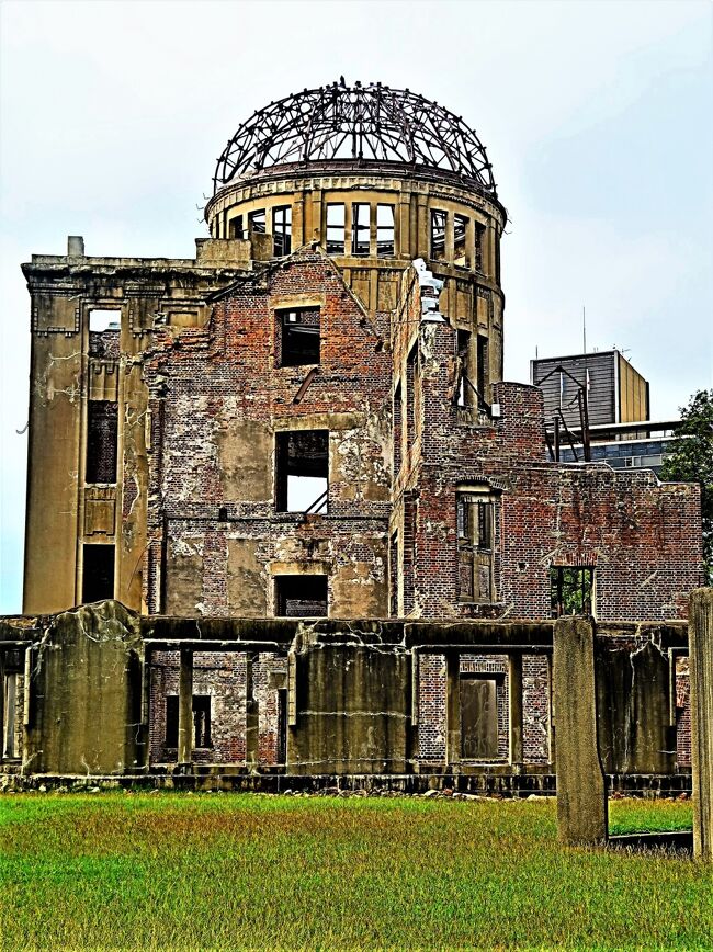 原爆ドーム（ Atomic Bomb Dome）の名で知られる広島平和記念碑は、1945年（昭和20年）8月6日広島市に投下された原子爆弾の悲惨さを今に伝える記念碑（被爆建造物）である。広島県物産陳列館として開館され、戦中から原爆投下時までは広島県産業奨励館と呼ばれていた。ユネスコの世界遺産（文化遺産）に登録されており、平和を訴える記念碑として、特に負の世界遺産と呼ばれている。<br /><br />「広島県物産陳列館」は1915年（大正4年）に竣工した。設計はチェコ人の建築家、ヤン・レッツェル。ドームの先端までの高さは約25メートルあり、ネオ・バロック的な骨格にゼツェシオン風の細部装飾を持つ混成様式の建物であった。<br />1944年（昭和19年）3月31日には奨励館業務を停止し、行政機関・統制組合の事務所として原爆投下の日を迎える。<br />1949年8月6日に広島平和記念都市建設法が制定されると、恒久の平和を誠実に実現しようとする理想の象徴として広島平和記念公園構想が本格化する。1951年（昭和26年）ごろにはすでに、市民から「原爆ドーム」と呼ばれるようになっていた。<br /><br />1955年（昭和30年）には丹下健三の設計による広島平和記念公園（平和公園）が完成した。この公園は、原爆ドームを北の起点として原爆死没者慰霊碑・広島平和記念資料館が南北方向に一直線上に位置するよう設計されており、原爆ドームをシンボルとして際立たせる意図があった。1966年（昭和41年）に広島市議会が永久保存することを決議する。<br />被爆50年にあたる1995年（平成7年）に国の史跡に指定され、翌1996年12月5日には、ユネスコの世界遺産（文化遺産）への登録が決定された。<br />第5回工事で鉄骨の塗り直し、補強材の補修が行われている（2020年）<br />建物内には原爆投下当時のがれきが散乱し、保存のために免震装置を下部に入れることに対して反対意見の理由になっている。また、外部から目立たないように補強の鋼材が入れられていることが上部から見たときに分かる。<br />（フリー百科事典『ウィキペディア（Wikipedia）』より引用）<br /><br />原爆ドーム　については・・<br />https://www.city.hiroshima.lg.jp/site/atomicbomb-peace/163434.html<br />