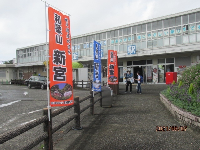 後で分かったことだが、速玉大社から新宮駅までは歩いて１５分程度。自分の足でもゆっくり歩いて２０分程度、とのことはバスに乗って駅まで行った時に理解できた。スマホで地図検索すれば容易に分かることだが、何故かスマホを取り出して小さい画面で検索するのが惑わしく、そのままバスを待った。田舎のバスで利用者も少なく、３０分も待たされることになったが、まあ、待つことは自分自身の骨休みにもなる。願わくばバス停の前にベンチでもあれば大感謝するのだが、それは欲張り過ぎだ。<br /><br />この周辺は落ち着いた住宅地で、この町の中流以上の家族が住んでいるようだ。佐藤春夫もこの辺りのどこかで生まれ育ったのだろうか・・。後年慶応大学に進学するが、鉄道が開通していなかった当時、上京するのも大変なことだっただろう。バス停の前に紀陽銀行の支店があり、土曜日なのに裏の駐車場に車を停め、行内のＡＴＭでお金を下ろして出て行くかなり頻繁な人々を見ている内にバスはやってきた。駅までは２停留所。５分程度だった。矢張りこれが最初から分かっていたら、長い間待つこともなかった。<br /><br />新宮駅は、嘗ての地方中堅都市の同じようなタイプの２階建てコンクリ造りの駅ビルで、多分ワンパターンの設計だろう。今はもうどこも近代的な駅ビルに建て替えられているが、ここ新宮はそのRenewalの波から取り残されたような感じだ。確か４０年前の和歌山駅も、規模の大きさは異なるが、こんな感じのコンクリートの２階か３階建てのビルだった。紀勢本線が和歌山から三重の亀山まで全面開通したのは昭和３０年代で、その時造られた駅ビルはもう既に６０年は経っている。南紀では中心の駅で、和歌山からはここまではＪＲ西日本が管理し、ここから東の線路はＪＲ東海が管理し、上手に棲み分けられている。折から丁度京都駅からの直通特急が到着する処。熊野三山の古典的な衣装を纏った地元観光協会の美人のモデルさんが、遥々京都からやってきた観光客を歓迎していた。