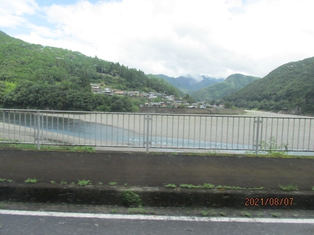 紀伊半島を北から南に流れ落ちる大きな川が南紀には二つある。その内古座川は近年流れの綺麗な事、水が澄んでいて、泳いでいる魚影も見える等々、自然愛好家の人気が高まり、それに連れて全国的にも人気度が増しているが、熊野川はそうした人気に左右されず、昔からどっしりと、滔々とした水量を抱え、有史以前からこの地方の中心的存在だった。歴史上、数々の伝説を残している徐福が、九州方面からやってきて、最初に上陸したのはこの熊野川河口付近と言われ、又、神武天皇が東征に際し上陸した地点もこの川の付近で、この河口近くには頓宮跡もあり、天皇が船出した渡御所も残されている。そもそも新宮はこの川によって発展し、川の畔に鎮座する速玉大社にはそうした史実の数々の史跡や伝承品が残されている。<br /><br />新宮は小さな町だから、駅前を出たバスは４－５分も走らない内に町を出て、川に掛かる熊野大橋は渡らずにその手前の１００ｍ程の短いトンネルを抜けると、そこはもう熊野川の右岸を走る道路になっている。これから暫くバスは川の右岸を北上し、窓の右手にずっと熊野川を見ることができた。バスの乗客は自分を入れて３人。二人は地元の人らしく、外の景色を眺めるでもなく、転寝でもしているようだ。このバスは終点が熊野本宮だから、そこに用事のある人か、途中のどこかの集落に行く人だろう。大きな荷物を持っている訳ではないので、里帰りでもなさそうだ。二人とも４０－５０代の中年男子。この川に生まれ育ち、今はどこか遠い都会に住んでいるような感じの中年だ。<br /><br />川は広々として水量も豊富だ。川原石も真っ白で、蛇行している場所では大きく河原が広がっている。川の途中途中に小集落が見える。川と共に生き、森と共に生計を立ててきた。だが、昭和平成令和の時代になって、そうした牧歌的な生活、生計はもう成り立たなくなりつつあるだろう。限界集落、と言ったら失礼か・・。この川筋に沿って、こうした小集落が点在し、その途中に熊野本宮があり、更にその先の上流に十津川村がある。今現在この村の村域は全国で一番広いという。熊野川流域の多くを占め、更に山中の吉野大台ケ原に続いているだ。明治の頃この村を襲った大山津波は多くの犠牲者を出し、村民の多くは離村し、集団で北海道へ移住した。その開拓集落は新十津川と呼ばれた。映画にもなった新十津川物語。鳥も通わぬ十津川の里。この流域のずっと先の方には、その集落があったのだ。