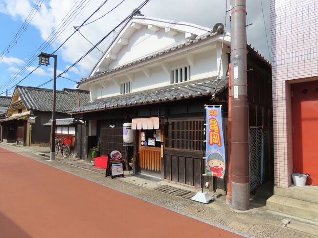 2021年7月14日(土)4時半前、形原神社から旧山陰街道を少し南に進むと高札所跡の案内板があるが、ここから西に延びる本町通りには京格子や虫籠窓など昔ながらの街並みが残る。高札とは現在で云うと新しい法律や罪人の罪状などを一般民衆に周知するために掲げる板札で、大手門へ向かう街道筋であるこの場所に高札を掲げる高札所が設けられていた。<br /><br />カラー塗装された本町通りを西に進むと、板壁の続く立派な屋敷があり、立札が建っているが、風雨で薄くなってなかなか読み取れないが、山脇東洋の生家とある。全然知らなかったが、江戸中期の1754年に京都の神泉苑の南にあった六角獄舎で、日本で初めて人体解剖を行ったお医者さんとのこと。解剖と云うと杉田玄白や前野良沢しか思いつかないが、彼らの1世代上で、彼らは山脇東洋の影響を受けているそうだ。この家は彼の生家である清水家の家屋(20歳の時に山脇家に養子で入った)。<br /><br />さらに西に少し進むと亀岡祭山鉾の一つの三輪山の説明が立つ(下の写真1)。亀岡祭とは上の形原神社のところで説明した鍬山神社の例祭のこと。10月25日の還幸祭に合わせて11基の山鉾が前々日の宵々山に建てられ、当日には巡行を行う。巡行する様子から、丹波の祇園祭とも呼ばれる。祭は室町時代に始まり、戦国時代の混乱の中で一時廃れたが、江戸時代になって歴代藩主の庇護を受けて町衆の力により徐々に復興した。<br /><br />太平洋戦争によって中断した祭が1953年頃に復活したが、当初はこの三輪山だけがここ本町の東端から西端まで運航されて祭を盛り上げていた。1749年に小振りの舁山(かきやま)として造られたが、1781年に曳山の鉾として改装された。大和の国三輪山麓に鎮座する大神神社の祭神である大物主大神をご神体とし、能楽「三輪」の後シテの女神像で表している。この説明板の近くの交差点を南に少し入ったところに保存庫がある。<br /><br />そこからもう少し西に進むと本町カフェと云う町屋造りの城下町歴史街並み案内所。2012年に亀岡市観光協会がオープンした観光拠点施設。木製の格子戸越しに街並みが見える部屋や亀岡城から譲り受けた襖絵のある部屋があるが、奥の部屋からは四季折々の表情を見せる庭を眺められる。<br />http://honmachi-cafe.com/<br /><br />一間一席のゆったりした空間で亀岡の食材を使った料理やお菓子を戴けるとのことで、一休みしてケーキとコーヒーを戴こうと思ったのだが、4時半過ぎで、店時間は5時だが、もう何もないとのことで何も戴けなかった。<br /><br />ただ、これは予定してなかったのだが、いつも常駐しておられると云うボランティアの亀岡ガイドの会の方が、帰る前に案内しましょうと云ってくださって、ありがたくお願いすることにする。後でお話ししてたら、私の卒業した立命館大学の先輩で同時期に衣笠キャンパスに在籍したこともあったのが分かって驚いた。まあ、地元やしね～<br /><br />まずは本町カフェと三輪山保存庫の間、北側への三差路を北に入ると、本町辻子と呼ばれる奥まった静かな路地に本町三ケ寺とも呼ばれる寺が3つ寄り添って並んでいる。<br /><br />一番西のお寺は本門寺。法華宗のお寺で山号は鷲林山、ご本尊は十界曼荼羅。法華宗の開祖である日蓮上人の弟子の日弁上人により開かれた千葉県茂原にある長国山鷲山寺の表本山として、鎌倉末期の正和年間(1312年～1317年)に日弁の弟子であった藤原定家の末孫、日寿により京都二条柳馬場の藤原定家の旧邸を寺として開創した。<br /><br />応仁の乱で焼失後の1493年に亀岡市西部、湯ノ花温泉の手前の山内郷奥条村(現在の稗田野町奥条)に移転し、さらに1600年に丹波亀山藩主となった前田玄以が現在地に移した。その時、本門寺は分家して一つは京都へ戻り、一条七本松にある宥清寺(ゆうせいじ)となっている。門前の題目石に1718年に建てられたもの(下の写真2)。<br /><br />そのお隣の壽仙院は浄土宗のお寺で、山号は霊松山。戦国時代の1572年に霊松山浄土寺として創建されたと伝えられるが詳細は不明。明智光秀が厚く帰依した大誉春光和尚を中興開山として亀山城の本丸の地にあり、1592年に小早川秀秋が息子の一存の菩提を弔うために米二石を寄進した五箇寺の一つとして壽仙院に改称、さらに城主前田玄以の時、現在地に移された。茶室への路地を進むと、水琴窟が設えてあり、清らかな音色を響かせている(下の写真3)。<br /><br />最後、法華寺は日蓮宗の寺で、室町時代の1464年の創建。関ヶ原の戦いで、西軍から東軍に寝返って徳川家康勝利に貢献したといわれる小早川秀秋が1589年に丹波亀山城主になり、寺院を城下に配置しなおした際に丁重に庇護されて移ったと云われている。城下の寺院本堂の中で最も古い1709年建造の本堂に祀られている高祖日蓮上人像は、身延山日号上人の作と伝えられている(下の写真4)。<br /><br />さらにこの本町辻子には5つのお堂が置かれている。路地の両端、東端の法華寺前には鬼子母神、西端の本門寺前には大黒さんが向かい合っている。さらに、壽仙院と法華寺の間に弘法大師堂、天満宮、妙見堂が並ぶ。なお、妙見堂に祀られている妙見大士大菩薩は身延山日堅上人の作と伝えられている。<br /><br />5時前、ガイドして下さってる先輩が、車で移動してもう少しガイドして下さると云うことで、ありがたくお願いすることにし、本町カフェに戻る。本町辻子を本町カフェに戻る路地に「かくれ布や」と云う看板が掛かかる入口がある(下の写真5)。中には入ってないのだが、日本の着物地と天然染め素材のオリジナル婦人服とバッグなどを製造・販売している店の工房らしい。店舗は京都の錦小路や八坂通り、嵐山にあるようだ。元々山口で創業されたそうだが、福岡を経て、2001年からここに工房を構えられているらしい。<br /><br />柿渋を使った染をされているそうだが、柿渋とは、まだ青いうちに収穫した渋柿の未熟果を搾汁し発酵熟成させたもので、日本では古くから、この柿渋を塗料や染料、あるいは万能民間薬として、マルチに活用して来た。家屋や生活道具、衣料品の耐久性を高め、防水・防虫・防腐・消臭効果を与えるなど、その効能は驚くほど多彩だそうだ。<br /><br />本町カフェの西側にも大きな三角の妻面が通りに面している妻入り造りの立派な古民家があり、「アレックス 探索・警備犬研究所」と云う看板が掛かっているが、調べても何なのか分からなかった。ガイドの方に聞けばよかったなあ・・・<br />https://www.facebook.com/media/set/?set=a.7576685922401366&amp;type=1&amp;l=223fe1adec<br /><br /><br />車に同乗させて戴き、西竪町の寺へ向かうが、続く