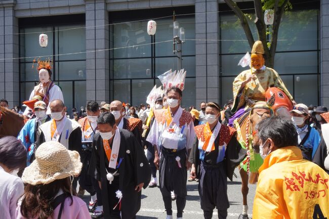 博多の祭りと言えば何といっても博多祇園山笠なんですが、博多どんたくも筥崎宮放生会と並んで博多三大祭の１つ。ただ、博多に2年半住んでいましたが、なんだかんだと他を優先して見たことがなく、そういう意味ではずっと気になっていた課題。それが今年の第61回博多どんたくは3年ぶりに開催というので、勇んで行って参りました。<br /><br />ところで、どんたくはオランダ語の休日を意味するゾンタークから。昭和37年に始まったものですが、一方でどんたくの中核である博多松囃子は治承3年（1179年）、博多の繁栄に貢献した平重盛が病没。生前の恩恵を謝すために始まったとされていて、とんでもなく古い起源です。<br />しばらく時代が下って、江戸期には福岡藩第2代藩主、黒田忠之が中止されていた博多松囃子を再興。博多松囃子は、福岡城へ福岡藩の藩主を表敬する年賀行事となり、博多の神社仏閣や町内有力者宅を巡り祝ったのだそう。この辺りで原型が固まった感じです。<br />さて、現代に至って。。博多どんたくのメインイベント「どんたくパレード」の先頭を飾る博多松囃子一行の構成は、傘鉾に続いて馬に乗った福神（福禄寿）、恵比須（夫婦の恵美須）、大黒の三福神とそしてしんがりの稚児。それぞれ四つの流れ（地区）が役割を担います。さすが賑々しくて目を引きつけるパーフォーマンスですが、その基本は市内の神社仏閣や多くの場所を祝い巡ること。松囃子のメンバーが道々ちょっとした縁起物を配ったりして、確かに祝う側とそれに謝する側の関係は沿道の見物客との間にもちゃんと成り立っていたような気がします。<br />松囃子に続く「どんたくパレード」の参加者は、約370の団体、1万4千人ほど。にわかのお面を付けたりしゃもじを手にして、色鮮やかなどんたく衣装に身を包んだ”通りもん”のいで立ちには、なるほど博多らしい個性と華を感じます。また、博多どんたくの歌「ぼんち可愛いや」にはあっけらかんとした明るさがあって、もう一つのベースが加わったよう。伝統の団体に加えて、バレエやバトントワラーのチームにマーチングバンドも多数参加。さらには九州各地からの参加団体もいて本当に様々なのですが、そういうごった煮の中にも博多松囃子に連なる言祝ぐの姿勢がそこはかとなく貫かれていて、やっぱりこれが博多なのかな。楽しくて奥が深いお祭りだと思います。<br /><br />結局、私は明治通りのリバレインの前に陣取って、午後1～5時までぶっ通しで拝見。正直かなり疲れましたが、また博多の理解が少し深まったし、がんばった価値は十分あったように思います。