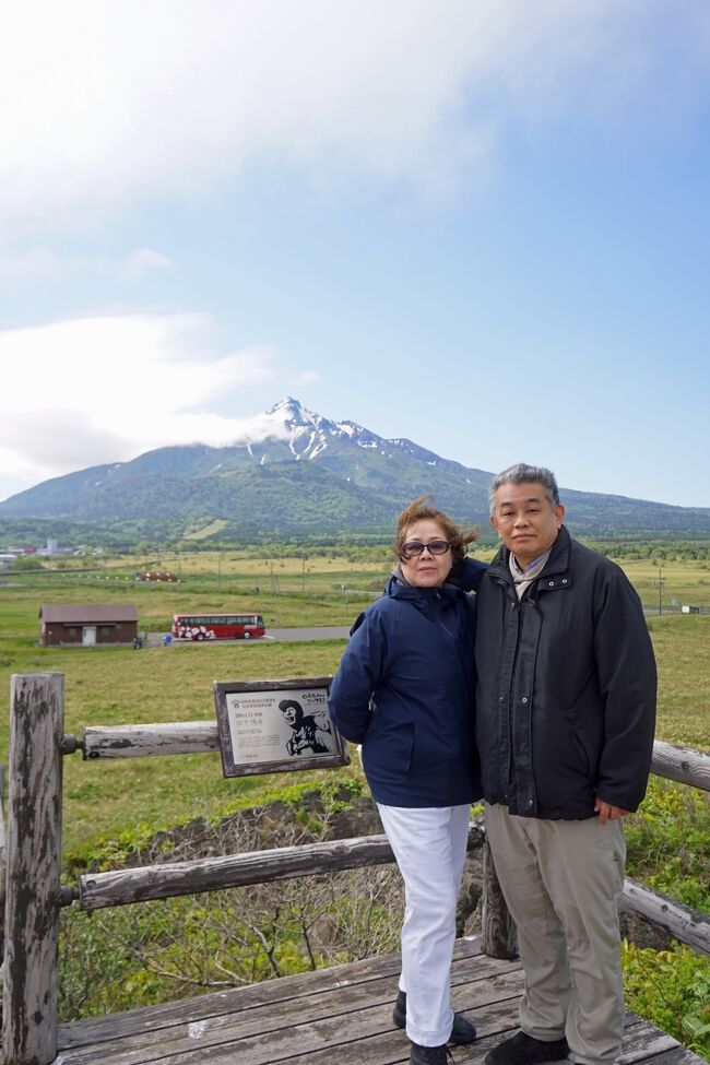 利尻島2日目は早朝に目が覚めたところからスタートします。午前5時前に1階の浴場に行って、1時間ほど散歩に出掛けることにしました。特に目的も無く「ぺシ岬」の山麓の会津藩士の墓の辺りまで行ってみました。昨日の夕方から利尻富士は姿を隠していますが、一瞬だけですが全体を見渡すことが出来ました。ホテルに戻って朝ご飯を食べても出発まで1時間以上あったので、ホテルのマップにあった「袋間（ふくろま）」にも行ってみました。これは獲れすぎたニシンを一時保管する場所で、石造りの立派なものでした。ツアー4日目は午前中は利尻島の観光が続きます。バスは昨日のように反時計回りに進んで、「富士野園地」に向かいます。この辺りまで来るとそれまで隠れていた利尻富士がきれいに見えました。ここは吉永小百合の映画「北のカナリアたち」のロケ地にもなった場所だと知りました。この映画について妻に尋ねたら、途中で「北の零年」と間違えていることに気が付きました。続いては「甘露泉水」という山の中の泉に向かいますが、両親が20数年前に利尻富士に登り来たときにはここを通ったのだろうと思うと感慨深いものがありました。利尻島の最後の観光は「姫沼」で、沼を1周ハイキングします。ここはバスガイドさんが同行して草花について説明してくれるので、妻も興味があるのでちゃんと歩いてくれました。木道も出来て散策するには良い季節で、天気も良くなってきたので利尻富士もきれいに見えています。ここのハイキングはとても良かったです。「姫沼」の散策が終わると利尻島の観光も終わりで、バスは「鴛泊港フェリーターミナル」に向かいます。