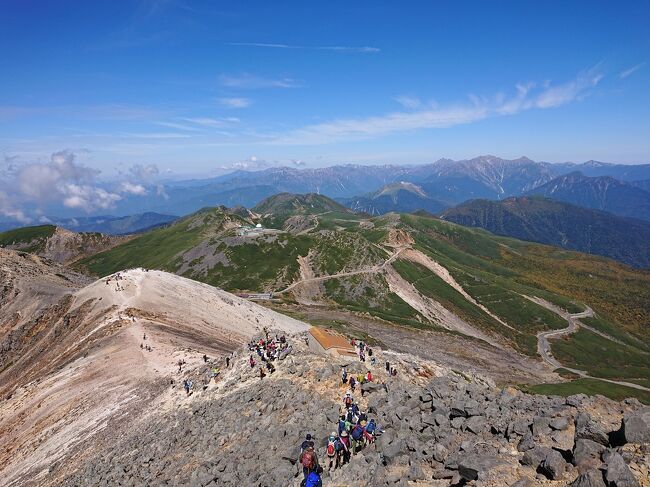 10月2日。北アルプスの南端にある乗鞍岳に登ってきました。<br />一度登った時は曇天であまり景色を見ることができず<br />いつかリベンジしたいと思っていましたが、なかなか天気や機会に恵まれず、行けてませんでした。<br />が、10月2日は日本全国晴れ予報。<br />意を決して行って来ました。<br />乗鞍岳はバスで標高2700mの地点まで行けるため、標高差300mほど登れば標高3000mの絶景を楽しめます。<br />天気がよかったため、北アルプスの山々が同じ目線で見ることができたり、3000mの高地の池や丁度見頃を迎えた紅葉も素敵でした。<br />とはいえ空気が薄く、思った以上に大変でしたが、それゆえ登頂した時の感動もひとしおです。<br />