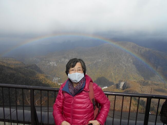 写真は層雲峡ロープウェイの展望台から見た虹のアーチです。<br />目線の下に虹を見るなんて生まれて初めてです。<br />今日は札幌駅を出発し、旭川駅に到着してすぐにバスで層雲峡を<br />訪問する予定です。<br />時々小雨が降る曇りがちな天気でしたので層雲峡の紅葉や絶景を<br />見ることは諦めていました。<br />でも麓からロープウェイが出発して暫くすると<br />後ろの窓の横に<br />ぼんやりした色彩が浮かんで見えてきました。<br />私の目が疲れて錯覚しているのかなと思っていると<br />そのぼんやりした色彩が右の方角に弧を描きながら<br />ゆっくり成長してきました。<br />「虹だ！虹が私たちを出迎えてくれたのだ！」<br />と胸がわくわくして来ました。<br />「どうぞ、途中で虹が消えてしまわない様に…。」<br />とお祈りしながらロープウェイのガラス窓から<br />写真を撮り続けました。<br /><br />私たちの旅と虹はご縁があります。