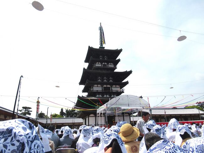 ４月21日、いよいよ薬師寺へ。<br />東塔落慶法要招待客は、東塔の前に並べられた椅子に座る。<br />しかしこれは大誤算で、法要の間中見えていたのは、前に座った人々の記念に頂いた手拭いを被った頭だけ。<br />なぜ手拭いか？というと、この日の奈良は気温２８℃。<br />容赦なく照り付ける太陽に、人々が思いついたのは、記念品の中の手拭いを頭に被るということだった！<br />帽子をかぶった人も数人いたが、この日急に暑くなったため、参加者は帽子の用意のない人が多かった。<br />もちろん私も例にもれずで、頂いた記念品の中からゴソゴソと手拭いを探し出す始末。<br />水煙に彫られた飛天がデザインされた素敵な手拭いだったが、背に腹は代えられなかった(^▽^;)<br /><br />東塔近くの金堂で儀式を見ていた相棒殿は、金堂の階段途中から儀式がよく見えたそうだ( ｀ー´)ノ<br />ちなみに招待状は、写経をしている本人にしか来ないので、同行者の席はない。<br />しかし今回は、あの暑い場所での儀式観覧で何も見えないよりは、別の場所で自由に観覧した方がよかったみたい。<br />次回はそうしようと思ったが、こういう儀式に次回はないですね(￣▽￣;)