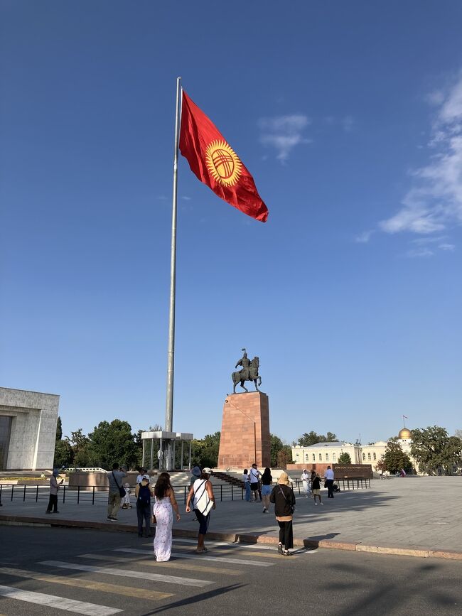 無事国境を越え、キルギスの首都、ビシュケクへ向かいます。<br /><br />国立博物館あたりで降りて、公園を歩きながら、アラ・トー広場前へ。<br /><br />ここで衛兵交代式を見学します。衛兵交代式をとても間近で見られましたよ！<br /><br />写真はキルギスの国旗とマナス王の像。