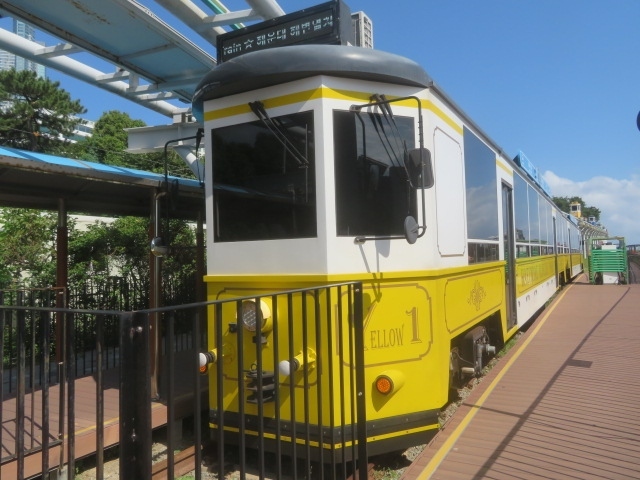 韓国釜山の旅をしました、龍頭山公園を散策した後、地下鉄1号線の南浦駅近くの地下街・南浦ショッピングセンター内を散策、チャガルチ駅付近から地上に出てチャガルチ市場へ、大きな建物市場棟内を見てから市場を散策、途中にある食堂で焼き魚定食の食事をしてから地下鉄1号線チャガルチ駅に行きました。・<br />地下鉄1号線・2号線を利用して海雲台（ヘウンデ）へ移動、駅を出て大通りの亀南路を歩いて海岸沿いに出ました、海岸沿いと散策路を散策して海雲台ブルーラインパークへ、海辺列車とスカイカプセルを見ました、乗車する人が行列していました、すごい人気のようです、散策路を歩いて海雲台のビーチ沿いバス停から急行バスを利用して釜山駅前に到着、釜山国際旅客ターミナルに向かいました。