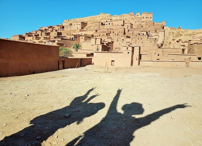 今までのイスラム圏の旅では、夜明け前のアザーンの呼びかけが、スマホの緊急地震速報ばりの大音響で、何事かと飛び起きるほど。<br />モロッコの朝は静か、全く気づかず。<br />「アッラーフ・アクバル」昼間も控えめの音量でありがたい。<br /><br />アラビア語の国名は“アル・マグレブ”太陽の沈む地という意味。<br />サハラ砂漠で朝日鑑賞はしたけれど、落日の瞬間と満天の星空を見ることが出来なかった。<br /><br />モロッコの人口構成を調べたところ。約65％がアラブ人、約30％がベルベル人で、残りの5％はその他。<br />もともとはベルベル人が住んでいて、あとからアラブ人がやってきたって、マダニさんが言っていたのを思い出した。<br />ラクダの御者さんのことを知りもしないでベルベル人と書いてしまったけれど、ホントのことは分からない。<br />外見や生活習慣の違いがあるのか、質問すればよかったな。<br />ガイドのマダニさん、ドライバーさんとアシスタントさん、このお三方が、1日5回のお祈りをちゃんとするのかが気になって密かに見張っていたのに、一度も目撃できず。<br /><br />バスの中でマダニさんがいろんな話をしてくれた。<br />条件を満たしていれば4人まで妻を娶れる話とか、農業のこと。<br />食料自給率100％以上で日本には農産物の他、タコ、イカなどを輸出しているって話も。<br /><br />小麦畑を通ったとき、小麦は不足していると説明あり。<br />調べたところ、モロッコの穀物の自給率(2020年統計)はすごく低くて21％。<br />毎日、ホブズを食べるんもんね、ケーキやクッキーなどお菓子も大量消費の国だから。<br /><br />現国王モハメッド6世のことも少しだけ話してくれた。<br />女性の権利に関する改正の話だったような、具体的にどんな話だったかを思い出せない。<br />記憶というのはあいまいで、人の悪口や自分の失敗談は面白おかしく覚えているけど、重要なことは片っ端から忘れていく。<br />バスの座席が後方だと質問も出来ず、聞き逃し、聞き間違い、勘違いばかり、謎のままのモロッコ。<br /><br />自分で撮った写真は撮影日時と場所が特定できるので問題無しですが、モロッコで編成した「チームM」のアルバムはPCに落とし込み、日付時刻を昇順としても、そうならない。<br />アルバムの追加順になってしまうので、どこで撮影したのか整理にとまどい。<br />モロッコ旅行のブログは、写真の共有・モデル、文章の校正など、仲良くなった“チームM”の隊員協力で無事にアップロードすることが出来た。<br />表紙の光影の写真は、アイット・ベン・ハドゥの集落と隊員お二人の影。<br /><br />隊員じゃなくて秘境好きの気の合う仲間、お笑いトリオ、私にとっては突然現れた益者三友かな。<br /><br />最終回は3/4~6日まで、3/7日本に帰国。<br />