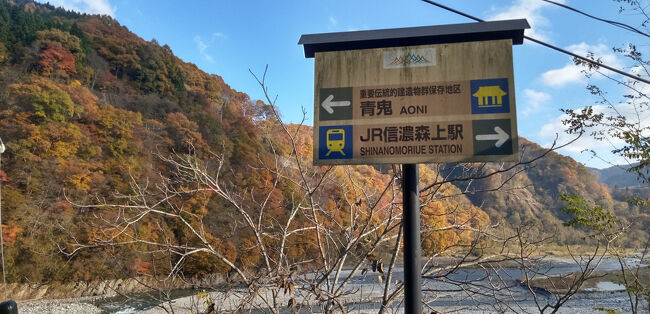スキーなどで有名な信州白馬村にある青鬼部落に行ってきました。<br /><br />まずは東京から中央高速道路をドライブ。<br />信州に入ったところで、松本空港に隣接した信州スカイパークに立ち寄りました。<br />広々とした公園にある展望施設は、ちょうど松本空港の滑走路の延長線上にあります。<br />飛行機の離着陸は見れませんでしたが、きっと真上を飛行機が飛ぶと迫力がある場所だと思いました。<br /><br />お昼は大町に近い松川村のお蕎麦屋さんで昼食。初めて行ったお蕎麦屋さんですが、比較的細く切られたお蕎麦の風味とすこし甘めのダシがとってもおいしかった。天ぷらのかき揚げは、別のお皿に盛りつけてでてきました。<br /><br />昼食後、大町市街を通った時に、大町商店街の中に男清水と書かれた水汲み場を見つけました。水道の蛇口になっていて、街中で美味しい湧き水が飲める場所があるのに驚きました。<br /><br />白馬村に入って、いよいよ目的の青鬼部落を目指します。国道から集落に向かう道に入ると姫川に架かる鉄橋がありました。<br /><br />川の清流と紅葉に彩られた山々の美しさは、息をのむほどです。このシーズンならではと思いました。<br /><br />さらに曲がりくねった細い山道を登って、ようやく青鬼集落に到着です。<br />このエリアは重要伝統的建造物保存地区になっていて、日本の農村の原風景と、北アルプスを展望できる場所です。昔は茅葺家屋がそのままだったそうですが、今は屋根はトタンで覆われています。<br />それでも大きな屋根の家々が建ち並んでいる景観は、他では見ることが出来ないような風景でした。<br /><br />深い山々の向こう側は、長野の鬼無里や戸隠になるので、青鬼と呼ばれるこの集落に伝わる鬼伝説が今でも生きている雰囲気を感じました。<br />集落を上に登って振り返れば、稲刈りは終わっていましたが<br />棚田越しに北アルプスを望むことが出来て、とてもすばらしい景観に感動しました。<br /><br />その後、白馬村に戻ってきた時に、白馬大橋を渡りました。<br />ここからの松川越しに見る北アルプスは、ほかに余計な人工物もなくて、自然豊かな山々と紅葉を楽しむことができました。<br /><br />夕刻、白馬ハイランドホテルにチェックイン、ふたたび露天風呂からの北アルプスを眺め堪能して地元料理のメニューもある夕食バイキングと地酒で充実した一日を満喫した旅になりました。<br />