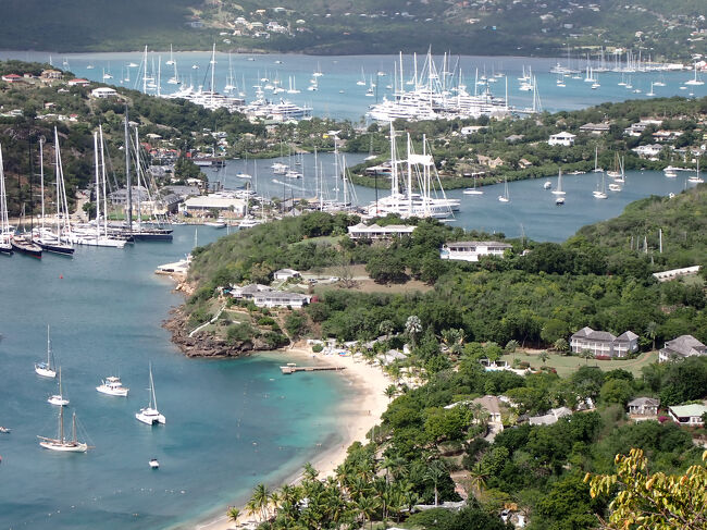 ＳＫＢを午後２時に飛び立ち３０分でＡＮＵ（アンティグア・バーブーダ）に到着。空港からタクシーでホテルに向かう。カリブの島々はホテルの名前だけで直ぐに分かるらしい。クルーズ客が大半でホテルの数が少ないのかな。渋滞の中進むと目の前には大型クルーズ船。ここがホテルやな。賑やかな繁華街と言うか雑踏の中のホテル。２つ星のホテルで古そうやけど結構広いし、ベランダも有って、クルーズ船が見える。早速街歩きして明日の観光をゲットしようとしたけど、火曜日は無理とか訳分らんわ。まぁ、クルーズターミナルやし、当日の朝にクルーズ客目当ての客引きが居るやろうとアンチョコに考えてた。翌朝は思惑通りネルソンズ・ドックヤード行きのツアーも見つかって乗っかった。<br /><br />アンティグア島とバーブーダ島の２つの主な島を国名にしており、種子島と同程度の大きさに１０万人弱が暮らしている。<br />１９８１年に英国連邦として独立。