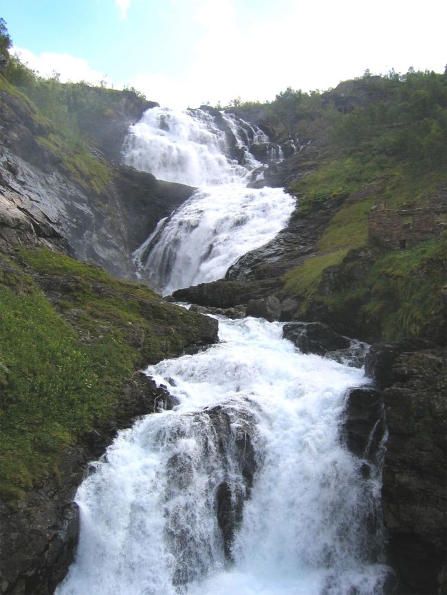 ヒョースの滝 : <br />列車はヒョースの滝の前でしばらく停車して、乗客が観光にそこで降りることができるようにしました。その滝は水力発電を可能にして、鉄道に電力を供給している。<br /><br />Kjosfossen Waterfall : <br />The train stopped in front of Kjosfossen Waterfall for a while and allowed the passengers to get off there for sightseeing. The waterfall enables hydroelectric generation, which supplies electricity to the railway.