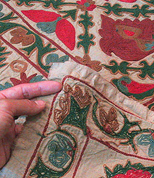 スザンニという布。<br />綿の布にかわいらしく刺繍した布。<br />クルド地方で多く見られる布で、売るために作られたものではなく<br />庶民が昔使っていたものです。<br />それを現地の絨毯屋などが買い取って<br />おみやげとして売られています。<br />トルコに限らず、ウズベキスタンからイラン、シリアなどで<br />手に入れる事ができます。