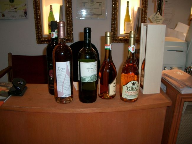 この後、私はもう１軒、カフェで休憩。今度はビールを飲みました。それにしても、私は休憩２度もしたのに妻は今日で最後だからと歩き廻っていましたねぇ。休憩後は「るるぶ」に載っていたワインショップ『エルシュ・ペシュティ・ボルハーズ』へ。このとき時計は6時をまわっていました。写真はこの店で買ったトカイワイン6本。2人で3本ずつ持ち歩きました。<br />