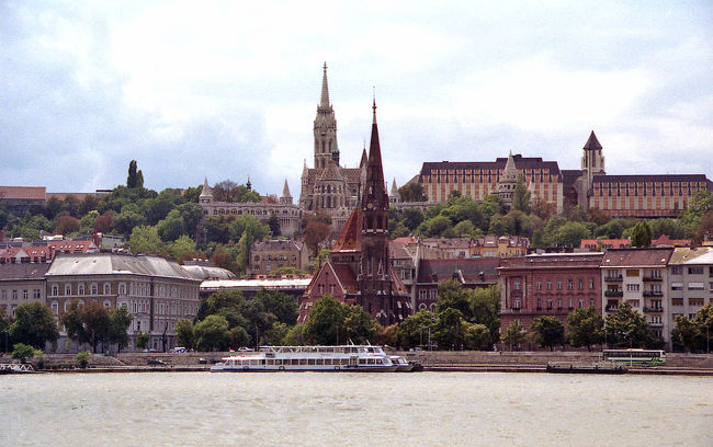 美しく青き(?)ドナウ<br />再びペスト地区に戻ってから、王宮の丘を見上げた写真。上の「ドナウの真珠」の写真と反対方向から撮影したもので、国会議事堂の前から撮影しています。<br />川沿いに建つ、細長い鐘楼を持つ教会は(たぶん)カルヴィニスト教会。ガイドマップにも載っていないので名前が不明確ですが、すごくキュートな感じです。<br /><br />それにしてもこの川、昔は本当にきれいだったんでしょうか？