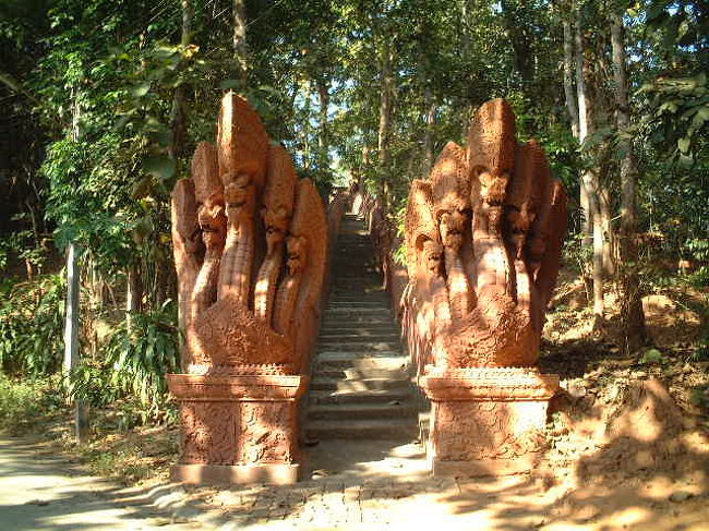 バイクで丘の上の寺院へ.<br /><br />「ワット・プラタート・チョーム・キティ」の<br />入り口。階段前にナーガがギロリ！<br />