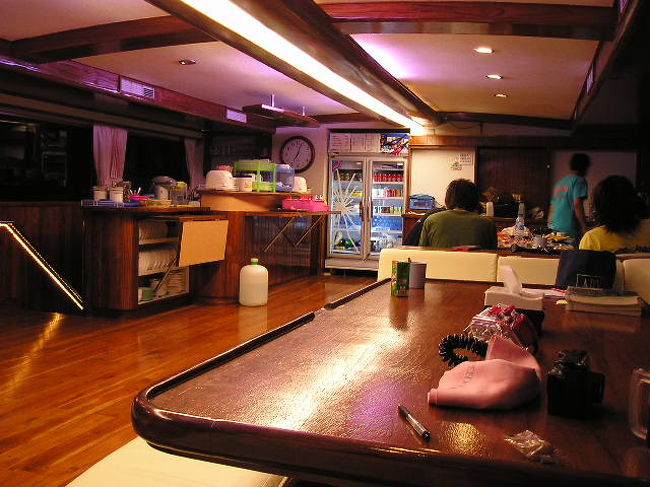 食堂兼居間です。<br />奥に冷蔵庫があって、ミネラル・ウォーターとペットボトル入りのソフトドリンクは飲み放題です。<br />左手のカウンタに、いろんな種類のスナックの袋が置いてあって、これもダタです。<br />その他、ホットドリンク、食パン、果物が置いてあっていつでも自由に食べられます。