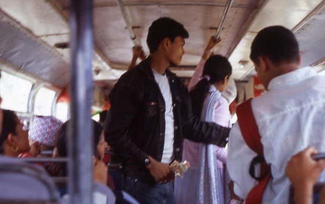 市バスの中で、お兄さんが料金を徴収している様子です。