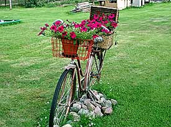 民家の玄関に、表札代わりに置かれた自転車の花飾り。とても愛らしくセンスの良い飾り付けです。