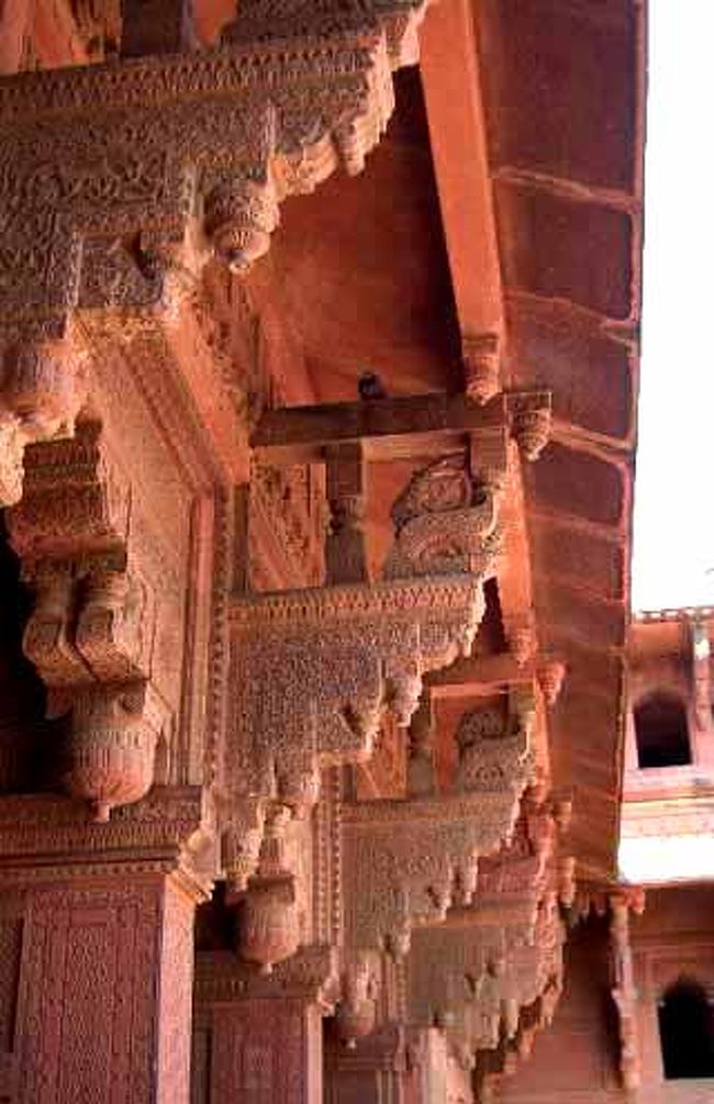 <br />王宮内部の回廊<br />イスラーム建築では広場への出入り口は尖上アーチ型<br />が多いけど、ここはちょっと違ってる<br />ヒンドゥー教の影響なのかな？<br /><br /><br />雨季に大量の雨が吹き込むのを避けるために、大きな庇(ひさし)を付けた！<br />その庇を支えるために、頑丈な軒持ちをいっぱい付けたのだが、細かな装飾だね