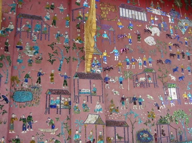 ある寺院の壁に描かれていた。<br />高床式の住宅で談笑したり、舟らしきものを作ったり、捕まえた獲物を運んだりと、ラオスの習俗がわかる。