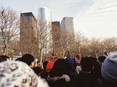 【バッテリー パークのパフォーマー】

ロワー マンハッタン（Lower Manhattan）の先端にはバッテリー パーク（Battery Park）という公園があります。
ウォール ストリート（Wall St.）を通って、自由の女神（Statue of Liberty National Monument）に行くフェリーに乗るため、バッテリーパークにやってきました。
予約はいらなかったのですが、チケットを買う人で結構混んでいました。
行列ができている中で黒人のパフォーマーが寒空の中、上半身裸になって何かをしていました。
見ているだけでも寒そうです＾＾；

Battery Park, New York City, New York