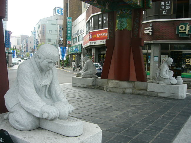 薬令市にある薬令門の下です。４つ違った石像がありますが，何をしているかわかりますか？薬を作っているんですよ。