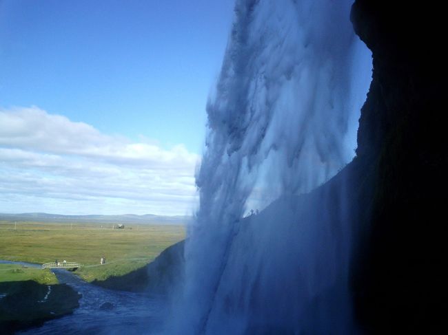 このSeljalandsfossは、滝の裏側を通ることができる。<br />早速、ジャンバーの上に防水服代わりのフリースを着て、いざ滝裏へ。<br />ゴーーーという滝の裏から見える風景が最高☆<br />丁度裏側は水は降ってこないが、滝の裏側から少しでた瞬間、風にも乗って水がバッシャ！<br />外人のおばちゃん、ちゃんとカッパを着込んでいる。<br />「えらいよ。あんた大正解だよ。」<br />と心で彼らを称えながら、ビッチャンコになったフリースの水気を切っている私。