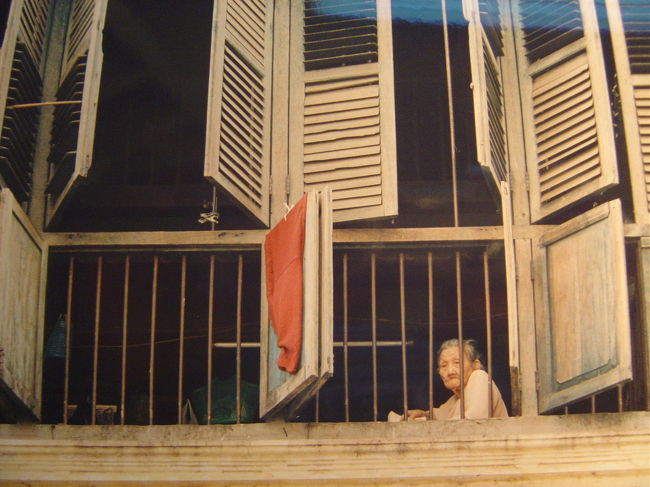 窓際にすわり通りの様子を見下ろして居るお婆さん,何もする事が無くそれが日課なのかも....