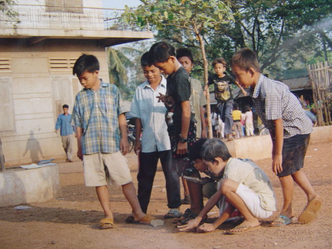学校の校庭にて,ビー玉で遊ぶ子供達.屈託の無い子供達を見て気が和む.