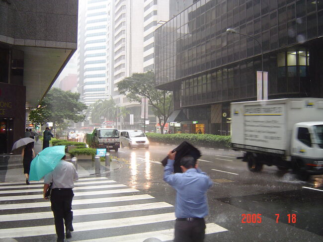 さて次はチャイナタウンに行こう！と意気込んでみたものの、ブギスの駅まで歩く間にどんどん空は真っ黒曇り空に･･･<br />ＭＲＴでラッフルズ・プレイスまで移動するも、外の出ると案の定雨が･･･<br />これがスコール並みの土砂降り、だのに全くやむ気配なし！！<br />果敢にも鞄で雨をよけようとしているおっさん！！<br />これではチャイナタウンは無理と、散策は明日にする事にしました。