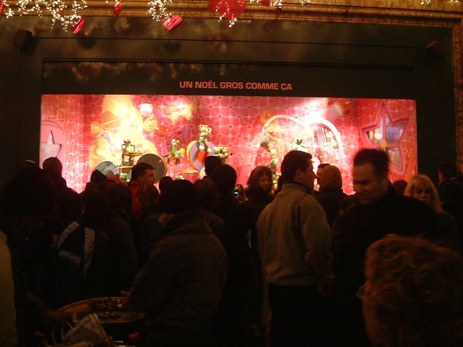 プランタンのショーウィンドにはクリスマスの飾りつけがしてあって、中では人形がくるくる回ったり音楽が鳴ったり。<br />子供も大人もみんな立ち止まって眺めています。<br />それにしてもすごい人。<br />これは９時前ですが、まだまだ人の波は途切れそうにありませんでした。<br />ヨーロッパのクリスマス、楽しいぞ！！