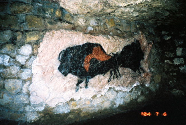 ★王宮地下迷宮 (Budav&amp;aacute;ri labirintus)<br /><br />王宮地下迷宮は、王宮の丘の地中にできた鍾乳洞を利用した迷路です。昔は貯蔵庫やシェルター等に使われていたそうです。入口は、通りに並ぶ家並みの中にひっそりとありました。看板プレートと、これから入ろうとする観光客がいなかったら、見過ごして通り過ぎてしまうところでした。地下は涼しくて、地上の暑さからしたら別世界のようです。チケットを買ったら、地図入りの小冊子を渡されました。てっきりガイド付ツアーで案内してもらえるのかと思っていましたが、どうやら一人一人勝手に歩くことになっているようです。<br /><br />はじめはチョロい迷宮だと思いました。地図を見ますと、多少、枝分かれした道がありますが、メインの進路はわかりやすく、ほとんど一方通行なのです。そして私のほかに歩いている観光客も、ちらほらいます。歩くペースが違うため、どこかで一緒になってもすぐに離れてしまいまい、たまぁに出会う程度で、ほとんど一人っきりで歩いてるも同然でしたが、2人連れ以上の場合は話をしながら歩いているため、姿は見えなくても声は聞えたりするので、すぐ近くにいることがわかります。メインのコースをそのまま歩くのも芸がないので、枝分かれの道だろうなぁと思っても、何やら面白そうな展示があるので寄り道したりしました。それでも、たいていすぐに行き止まりになったので、元の道に戻るのは簡単でした。道々、進路を示す矢印もあったので、安心できました。<br /><br />中は、鍾乳洞がそのままむき出しではなく、れんがで固められた上に、観光客向けに演出がなされていました。展示セクションがいくつかに分かれています。入口でもらった地図付の小冊子にも簡単に説明がありました。<br /><br />最初のハンガリーの古代の伝説時代のセクションでは、彫刻やトーテムがうす暗闇にぬぅっと現れるのにちょっとビビりました。音楽に音響効果もあって、やや演出過剰という気がしなくもありませんでしたが、よくわからなくてもいいからとにかく楽しみたい観光客である私にとっては、悪い気はしませんでした。<br /><br />先史時代のセクションでは、ラスコーの洞窟を模した動物のレリーフがあり、ラスコーの洞窟見学を疑似体験ができた気がして嬉しくなりました。ていうのも、その昔、マドリッドの国立博物館のラスコーの洞窟のレプリカ室では、ちょっと期待してたのと違ってがっかりした覚えがあるからです。逆にいうと、そういうのが期待どおりということは、素人でも容易に満足できる「やらせ」ということになるのでしょうか。<br /><br />（写真は、その先史時代のセクションの、ラスコーの洞窟を模した動物のレリーフです。）