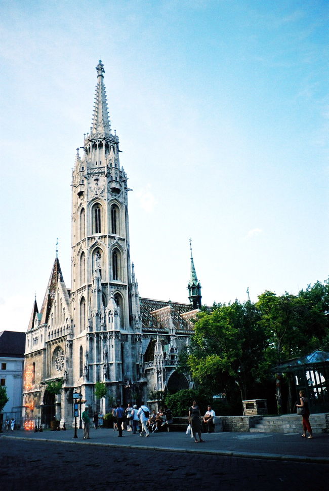 ★マーチャーシュ教会 (M&amp;aacute;ty&amp;aacute;s templom)<br /><br />乱暴な比較かもしれませんが、マーチャーシュ教会とその前の広場の雰囲気は、ずウィーンの聖シュテファン寺院と寺院前の広場を連想させます。ウィーンのを少し縮小したってかんじがしました。もっとも、ウィーンを連想させるのは、あくまで教会と、広場でもそのすぐ前のところだけです。その周辺は全く雰囲気が違うので、念のため。<br /><br />しかし、教会の中は、シュテファン寺院と全く違いました。少し東洋やイスラムチックな雰囲気が感じられました。構造は3廊式のゴシック様式。天井に壁に柱の一面に、紋章っぽい模様と絵がぎっしりでした。東方教会やイスラム風の建物に興味がある私の好奇心を大いに満足させてくれる教会でした。ハンガリーの一部がオスマン・トルコに占領されていた時代にこの教会がモスクに改築されたという歴史があるせいでしょうか。<br /><br />そう、日本でヨーロッパ史を学んでいると、ウィーンがオスマントルコに2度包囲されながら、そこで食い止めて撃退できたおかげで、西欧世界が守られた、ということばかりに焦点があてられてしまいますが、それはつまり、ちょっと考えれば（本当はわざわざ考えなくても）すぐわかることですが、お隣のハンガリーはトルコに占領されてしまったということでした。その後、オーストリア・ハプスブルグ家がハンガリーからもオスマントルコを撤退させたが、代わりにハンガリーの支配者に収まりました。そうなると、ハプスブルグ家はいわば勝者側なので、西欧史の立場からは、オスマントルコからの解放！のようなプラスイメージを持ちやすくなります。<br /><br />しかし、ハンガリーにとって、オスマントルコの支配時代の方が、ある意味緩やかで、ハプスブルグ家の支配の方が過酷だった一面もあったそうです。オーストリア・ハンガリー二重帝国の成立は、そんなハプスブルグ家に対するハンガリー人によるたび重なる反乱と、ハプスブルグ家の弱体化と当時のヨーロッパ情勢による妥協の産物といえます。でも一方、同じように民族の独立を求めていたチェコとスロヴァキアがハンガリーと同様の権益を認められなかったことを考えると、ハプスブルグ帝国とハンガリーは、まだ幸せな「結婚」に思えました。いやはや、本当に、歴史はひとつではないとしみじみ思います。<br /><br />マーチャーシュ教会には、他の教会の例にもれず宝物館がありました。街の主要な教会の宝物館は、入場料が余分にかかっても、なるべく見学するようにしています。それほど規模が大きくなくても、たいてい、豪華で手の込んだ聖遺物入れや十字架などの宝物、聖職者のマント、手書きが美しい聖書、教会の内外を飾る聖像のオリジナルなど、多岐にわたるコレクションを楽しむことができるからです。マーチャーシュ教会の宝物館も、期待通りのすばらしいコレクションぞろいでした。特に、宝石がたくさん使われた聖遺物入れを見るのが、最近の私のお気に入りです。ただし、それは宝石や鉱物に関心が高まったためなので、教会宝物を見ても、その意匠の見事さに感心するより、この宝石は何だろう、とついついそのことばかり、考えてしまいます。<br /><br />途中、フランツ・ヨーゼフ皇帝とエリザベート皇后のハンガリー王・王妃としての戴冠式のときの壁画がありました。ハプスブルグやエルザベート関係の本の写真でよく見かけた絵ですが、オリジナルはこれでしょうか。式はこの教会で行われたのだから、充分ありえます。エリザベートの大理石像もありました。2人連れの、英語がネイティブの女の子たちがいて、うち一人がエリザベートのファンらしく、大理石像を見て感激していました。連れに一緒の写真を嬉しそうに撮ってもらい、自分でも大理石像だけの写真を何枚か撮っていました。なんだか微笑ましい光景でした。