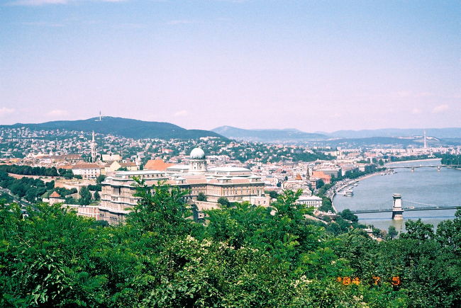 ★国立博物館 (Magyar Nemzeti M&amp;uacute;zeum)<br /><br />（写真は、王宮の丘の三位一体広場で、実は国立博物館と関係ありません。関係ある写真を撮らなかったので……。この写真は、ブダペスト初日の現地ツアーを利用した市内観光で、ゲッレールトの丘にある展望ポイントから王宮方面を撮ったものです。）<br /><br />狙ったわけではないですが、昨日の王宮の国立絵画館に続き、国立博物館も今日はタダで入れる日でした。入ったのは14時すぎですが、閉館の18時までじっくりここで腰をすえるつもりですし、入場料もタダだから、ちょっくらオーディオ・ガイドでも借りようかと思いました。レンタル料は750HUF（約375円）。私にとっては全く、許容範囲内の料金です。<br /><br />ところが、保証金として10,000HUFか40Euro、あるいは身分証明書としてパスポートを預けなければならないとのこと。手元にある現金は10,000HUFぎりぎり。パスポートは、オーディオ・ガイドを借りる程度で肌身からはなすつもりはありません。いそいそと準備してもらったのに悪いとは思いましたが、やめることにしました。すると係員は、「とってもすばらしいオーディオ・ガイドなのに、10,000HUFくらい持ってないの？」と不満そうでした。<br /><br />でも、もう一度、オーディオ・ガイドの料金表をよくよく見たら、最初の1時間は750HUFですが、オーバーすると30分ごとに250HUFとありました。休憩も含めてゆっくり回るつもりなので、きっと1時間では足りません（実際、博物館を出たのは、入場してから約3時間後）。やめてちょうどよかったです（すっぱいブドウとキツネ、すなわち、負け惜しみ！？）。<br /><br />最初にあった考古学のコレクションをざっと見たあと、企画展「ハンガリーとヨーロッパ (Mayarorsz&amp;aacute;g &amp;eacute;s Eur&amp;oacute;pa)」をゆっくりまわりました。ヨーロッパの中でのハンガリーの意味をふりかえる企画展で、当然、今年2004年5月のハンガリーのEU加盟にちなんで開催されたものでしょう。セクションは6つに分かれていました。地理的にヨーロッパの真ん中に位置しているハンガリーの、ヨーロッパ史上での役割や意味を表すようなエンブレム、歴史的エピソードの版画や風刺画を、時代で区切って展示されていました。最後のセクションでは、世界遺産に登録待ちのハンガリーの各地の景観の絵や写真が展示されていました。どれもこの国立博物館所蔵の資料だが、ふだんは展示されていないものをこの企画展のために特別にそろえたようです。<br /><br />セクションごとの説明パネルにはハンガリー語に英語の訳が併記されていました。展示の1つ1つの説明プレートも英語付です。もっとも、後者の英語はだいぶはしょられていました。ハンガリー語で10行以上、ぎっしり解説があっても、英語の方は、展示の絵が何を意味するのか、という、ほぼタイトルのみの1行だけだったりすることもあります。でも、あんまり詳しくても、体力・気力ともに読み切れる自信がないので、ちょうどよかったです。だから、がんばって全部読みました。それに、企画展の会場は、小ホールのような展示室1室のみ。あと残りがどのくらいか、先が見えるからこそ、がんばれたともいえます。14時20分からこの企画展の見学を始めて、終わったのは15時15分。さすがにぐったり疲れました。20分ほど休憩。<br /><br />15時35分から17時25分、メインのハンガリー史の展示室を回りました。こちらは展示室が30以上あります。さすがにメインだけあって、展示品もさらに充実していました。今度は部屋ごとに、ハンガリー語と、ほぼ同じ量の英語が書かれた説明パネルがありました。すでにだいぶ疲れていたので、全部は読んでいられませんでした。しかし、読まないと展示の意味がほとんどわからないので、最初の半分ずつぐらい読みました。じっくりでなく、ざっと。<br /><br />なので、私に背景知識が全くない時代は、内容がなかなかピンときませんでした。Ottomanをオスマントルコでなくドイツのオットー王朝かと勘違いしたり……。実際、ハンガリー史でオットー王朝と確執がなかったわけでもないから勘違いしたのですが、そもそもオットー王朝とオスマントルコとでは、時代が違いすぎます。人物も、ハンガリー史上の重要人物といっても知らない名前ばかりが並ぶことが多く、ちんぷんかんぷんです。歴史展なので、意味がよくわからないと興味が薄れるものも出てきてしまいます。ここでも勉強不足を痛感しました。それに、またしてもチェコ史とごっちゃにしている自分に気付かされます。どちらもハプスブルグ家と大きな係わりがあって、同じように反乱や抵抗の歴史が展開されているように見えます―――私からは。だから、中途半端な知識では、ますますごっちゃになりやすいようです。<br /><br />12〜3室目、ハプスブルグ家のマリア・テレジアとヨーゼフ2世治下の啓蒙時代のセクションのあたりで、「地球の歩き方」のことを思い出しました。この本の巻末にはハンガリー小史が巻末に載っています。そして、一休みするときに観光案内やレストラン情報でも読もうと思ったので、入口で手荷物を預けるときに一緒にクロークに預けず、手に持っています。巻末の小史は、一度は目を通していますが、内容は既に忘れています。早速、手近なイスに座って読み直しました。そして、よし、これならOK！とばかりに、最初の展示室まで戻って改めて展示を見直しましたが……うーん、「地球の歩き方」で説明が詳しいところと、展示で詳しく説明されているところが、どうも一致しないようです。「地球の歩き方」で詳しいところは、展示ではいくつかの時代すらも一室にまとめてあっさりすませ、一方、展示の方で細かくセクションに分かれているところは、「地球の歩き方」ではさらっとはしょっていたりします。日本人にとってわかりやすいハンガリー史と、ハンガリーの人々にとっての自国の歴史では重点の置きどころが違う、というのがこんなところからわかって興味深かったですが……うーん、展示を知るには、やはりパネルの説明を読むのが一番のようです。<br /><br />第一次世界大戦突入から現代、ハンガリーが1898年に民主化するまでの時代時代が近いだけあってか、展示物はダントツに多く、詳しくなりました。セクションの分け方も、5年ずつくくらい、と短くなりました。戦中に流行った商品や、社会主義政府の宣伝ポスターが面白かったです。なぜか、スターリン像がありました。さすがに彼はひと目でわかります。逆に、ハンガリー近代史上の重要人物たち、たとえばプチ・スターリンと言われたラーコーシや、ハンガリー動乱後にソ連に処刑されたナジ・イムレ、それからもう少し最近のカーダールなどは、ブダペストに行こうと決めて下調べを始めてから名前だけは何度も目にしましたが、顔は、写真であろうが絵であろうが、見るのは初めてです。<br /><br />もっとも、ブダペストに行こうと思ってから初めてこれらの人々の名前を目にしたというのは、考えてみたら少し情けないかもしれません。ハンガリー動乱もそうですが、ベルリンの壁の崩壊のきっかけとなった、ハンガリーが西側へ亡命する人のために国境を解放した事件などは、こうして歴史として捉えられる以前に、時事問題だったはずなのです。時事問題にうとい……なかなか関心を抱かない自分がちょっと情けなくなりました。<br /><br />このハンガリー史のセクションで1時間50分かけました。それでもハンガリー語がわからないことと背景知識の欠如のせいで、展示物の意味や重要さがピンとこないのが多くて、たくさんの情報がつまっている展示の、ほんの氷山の一角にしか触れられなかったと思います。もっとも、体力・気力もだいぶ尽きていたせいで、それ以上は時間をかけるのは難しかったです。<br /><br />この博物館の前の広場は、1848年、オーストリア・ハプスブルグ家に対してハンガリーの独立を求めた市民蜂起の舞台となり、1万人の市民で埋め尽くされたそうです。───って、一体、広場のどこなのでしょう？　あの工事中の正面入口のことでしょうか。そんなに広かったかしら。工事中だから狭く見えたのかしら。柵のせいかしら。1万人の人間が集まるとどんなかんじか想像がつかないのですが、あそこにそれだけの人数が集まったというのも、ピンときません。<br /><br />ちなみに、国立博物館前が市民蜂起の舞台というのは、プラハもそうです。あちらは、そもそも国立博物館の前から延びる通りが、「プラハの春」の舞台のヴァーツラフ広場です。ほぅら、ここでも比較対照できる。……ま、我ながら随分乱暴な比較だと思いますけど。