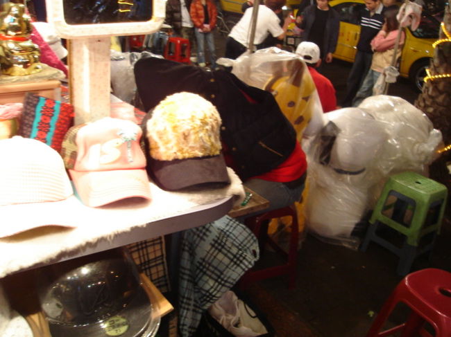 帽子屋さんの屋台で寝ている店員さん