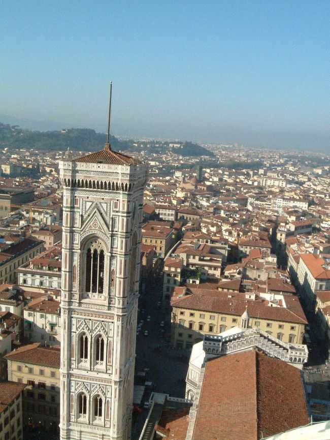 朝9時15分。オープンしてまもなくクーポラに登る。<br />料金は6ユーロ。<br />まだ早い時間のせいか混雑はさほどなかったので、463段の階段をマイペースで登ることができた。<br />すっきりと晴れ渡った11月の青空は、空気がひんやりと冷たく、とても神聖な雰囲気。<br />果てしなく広がるティラミス色の町並みをぐるりと見渡しながら、母に「あの建物が○○、これが△△」とひとしきり解説する。<br />20分ほど頂上からの景色を堪能したのち、階段を下り、内部とサンジョヴァンニ洗礼堂、ジョットの鐘楼をじっくり鑑賞してから、ドゥオモ広場をあとにした。