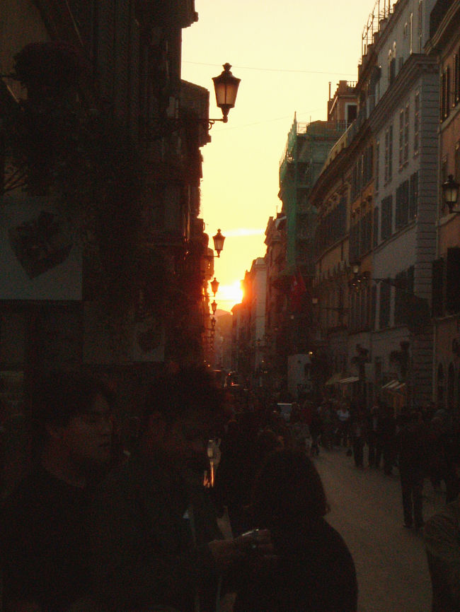 スペイン広場を起点にのびている、高級ブランド街、コンドッティ通り。<br />ブランドショップには用事がなかったけど、どんな雰囲気なのか覗こうと思って通りに足を踏み入れると、ちょうど通りの隙間からまぶしい夕陽が顔を出していた。<br />規則正しく並んだガス灯のシルエットがとても美しい。<br />