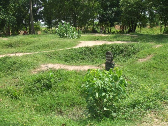 マス・グレイブ（集団墓地）<br />墓地といっても「穴」だった。ここに埋められていた人たちの骨が、今はストゥーパの中に<br />ちなみに、今のキリングフィールドはトンボが舞って鳥が歌いながら飛ぶとても平和なところだった。それが余計に昔ここで何があったかを思い起こさせる。