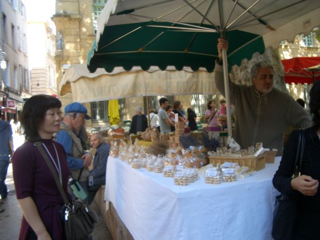 エクス・アン・プロヴァンスの朝市。<br /><br />エクス・アン・プロヴァンスではカリソンというお菓子が有名。ガイドに薦められて、母猫が買う。15個で７ユーロ（1000円弱）はちょっと高いんじゃない？<br /><br />アーモンドを砂糖で固めたものなのだが…、良薬口に苦し、ぢゃなかった、名物に旨い物なし、ですな。