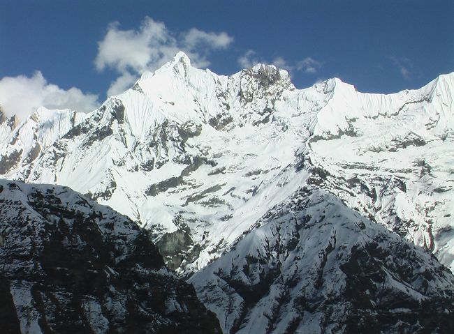 ベースキャンプには５軒のロッジがある。<br />ガンダルバチェリ（6248m）が雲間より見える。