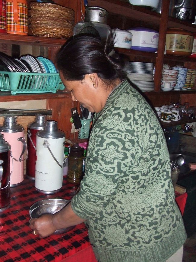 夕食のベジタブルモモを料理中のお母さん。<br /><br />ネパール風餃子のモモは注文を受けてから生地を練る。<br /><br />以下モモの作り方：<br />１．小麦粉と水で生地を練りのばし棒で少し厚めにのばす。<br />２．７センチくらいの円形型でぬく。<br />３．具は青菜、赤たまねぎ、にんじん、にんにくのみじん切りを炒めてスパイスで味付け（本当はこのスパイスが何かが重要…）<br />４．３の具を２の生地で包む。包み方は何パターンかあるけどここのは日本の餃子と同じ。<br />５．蒸し器で蒸して完成。<br />＊ソースはトマトとにんにく、赤たまねぎのみじん切りを炒めたソースで。
